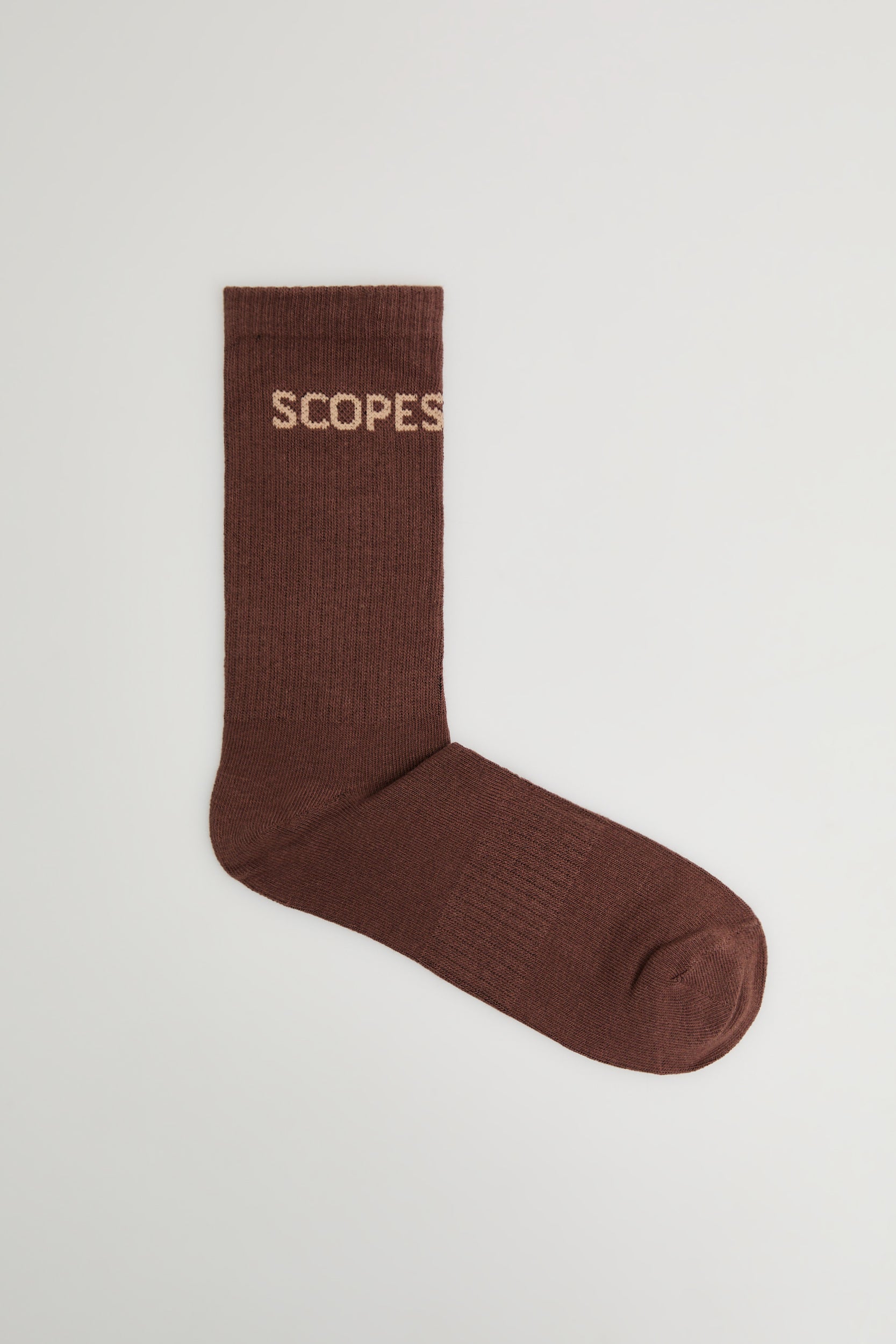 Brown cotton socks featuring the Scopes logo
Pair of brown socks with embroidered Scopes logo